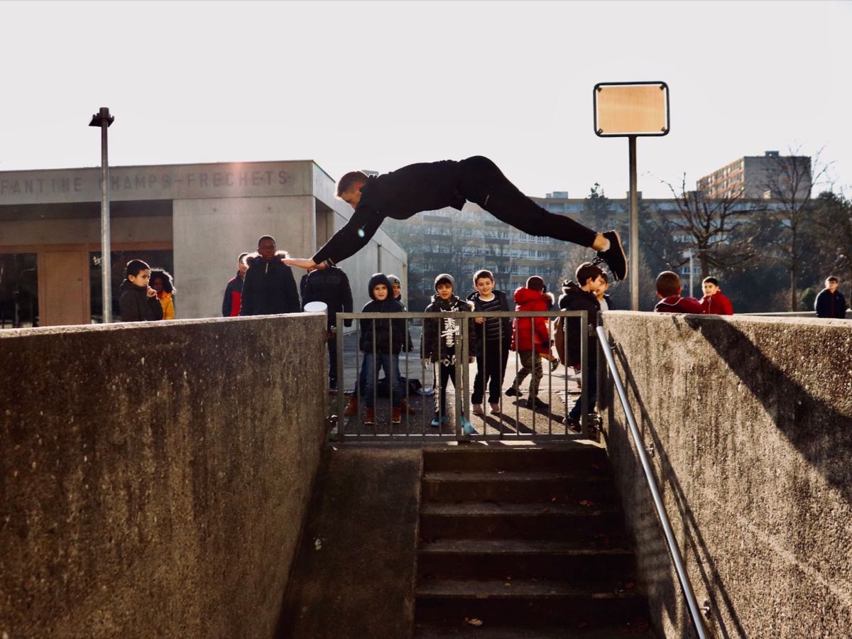 Démonstration d'un franchissement d'obstacle devant un groupe pendant un cours de parkour dans la région lyonnaise